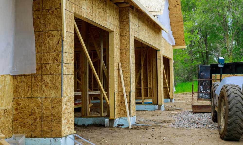 Currently, joist framework for house is being installed, along with gutter holders soffit fascia trim on house under construction.
